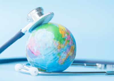 stethoscope,wrapped,around,globe,on,blue,background.,save,the,wold,