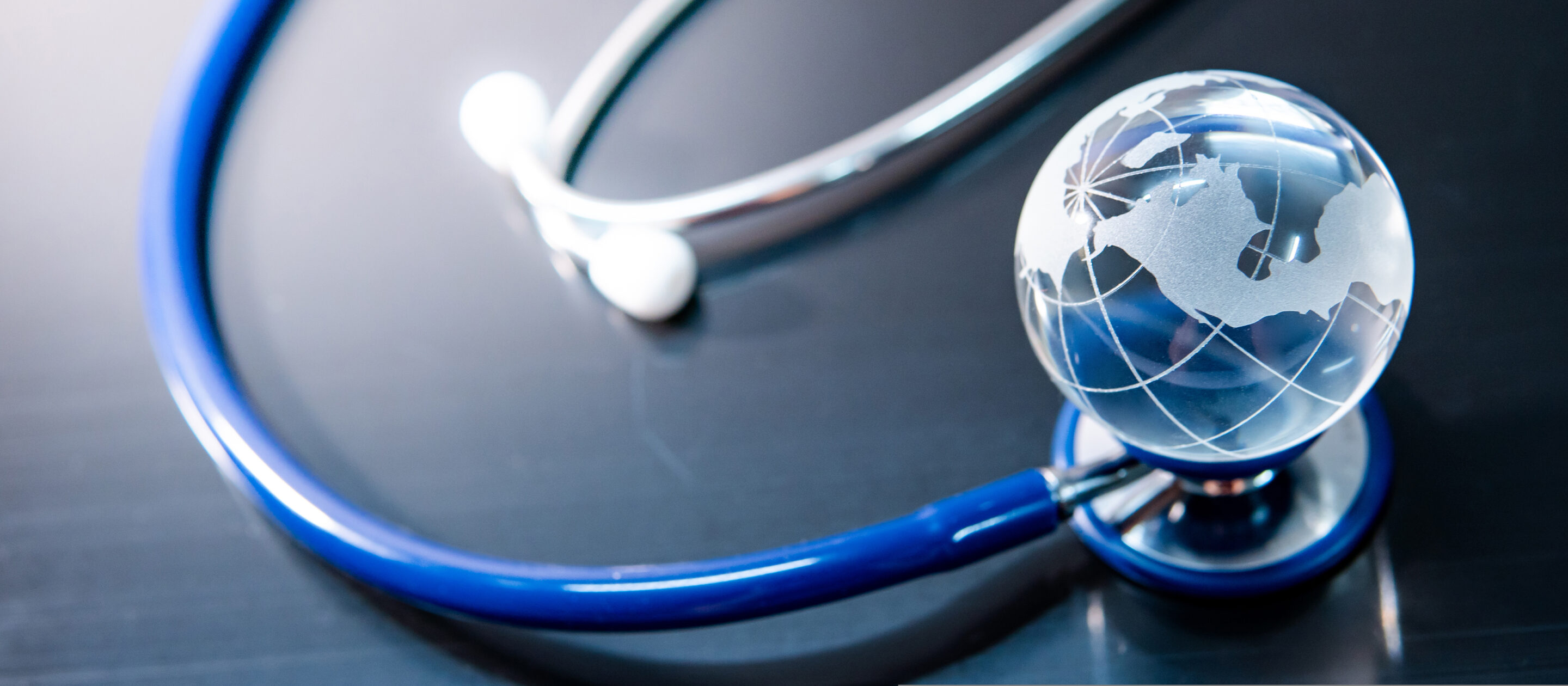 global,healthcare,concept.,world,globe,crystal,glass,on,blue,stethoscope