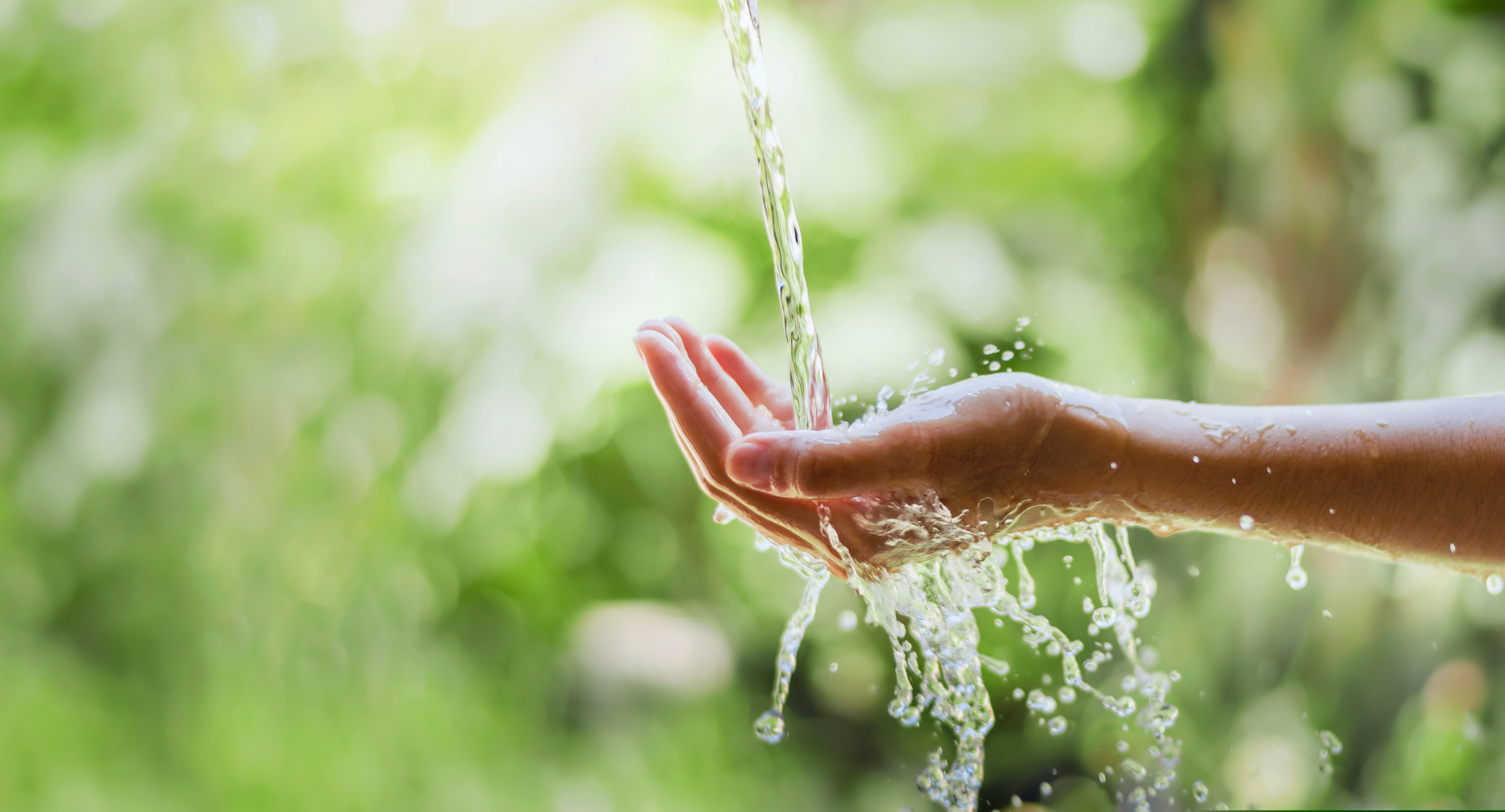 water,pouring,flow,on,woman,hand,on,nature,background