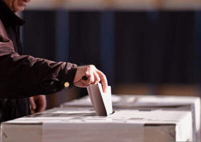 hand,of,a,person,casting,a,vote,into,the,ballot