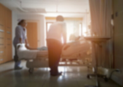 doctor,and,nurse,talking,with,patient,lying,in,bed,,blurred