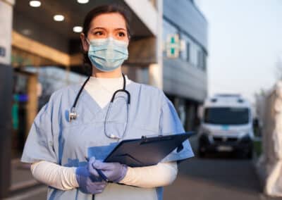 young,female,ems,key,worker,doctor,in,front,of,healthcare